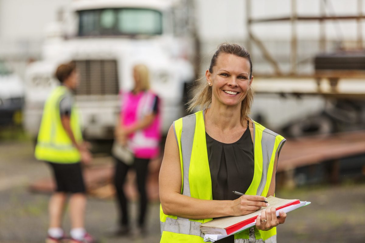 Image of empowered happy women working in the transport industry wearing high visibility clothing.